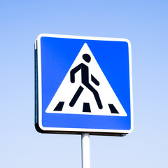 A pedestrian crossing sign. Sign on a blue sky background.