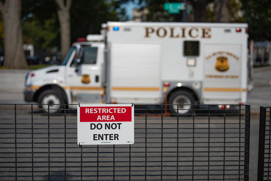 Restricted area "Do not enter" sign on blurred US secret service uniformed division Police truck parked background