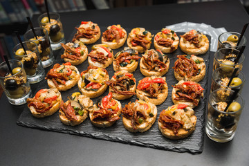 Small hamburgers and sandwiches are served on the same plate as a snack.
