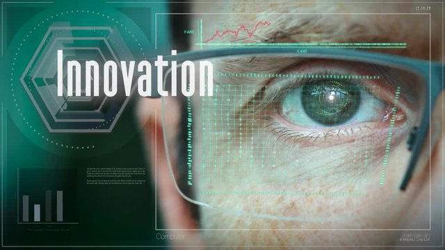 A close up of a businessman eye controlling a futuristic computer system with a Business Innovation concept.