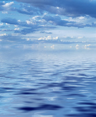 Clouds reflected on endless calm blue water