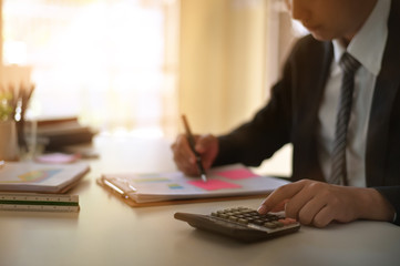 Businessman doing finances and calculate on office desk about cost at home office.