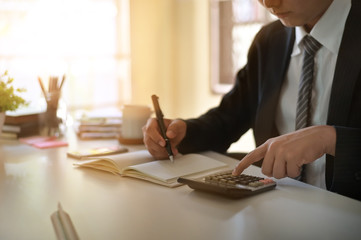 Fototapeta premium Businessman doing finances and calculate on office desk about cost at home office.