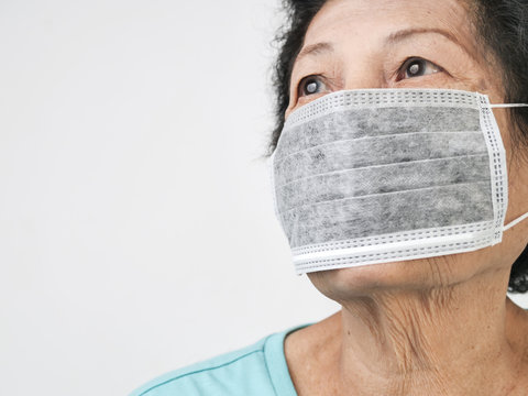 Asian Senior Woman Wearing Earloop Mask On White Background.