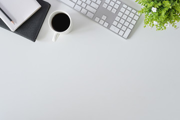 Flat lay top view office desk. Workspace with keyboard and office supplies with coffee on white background.