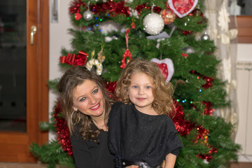 mother and daughter decorating christmas tree