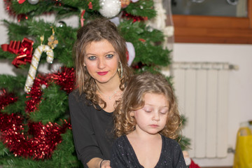 Obraz na płótnie Canvas mother and daughter decorating christmas tree