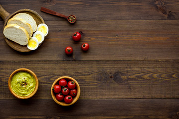 Healthy breakfast. Toasts with vegetables and guacamole on dark wooden background top view copy...