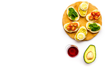 Healthy snacks. Set of toasts with vegetables like avocado, guacamole, rocket, cherry tomatoes on white background top view copy space