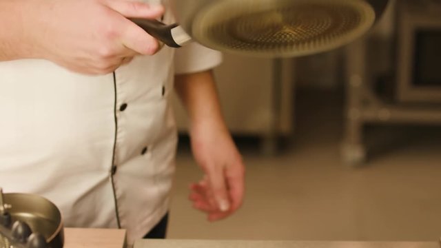 Chef bakes pancakes in a pan. Electric stove in the restaurant kitchen