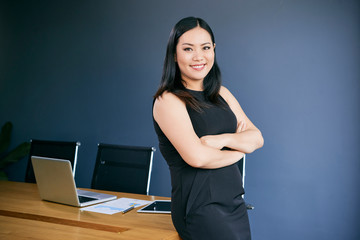 Portrait of cheerful Asian businesswoman with her arms folded