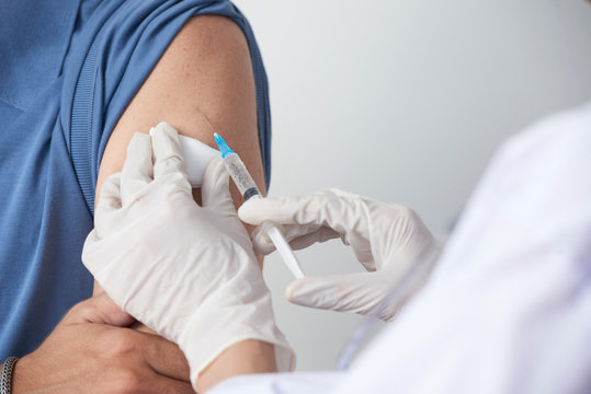 Close-up image of man receiving injection of vaccine