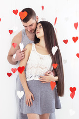 Valentines day lovely caucasian couple staying white background and red heart air around. celebration isolated