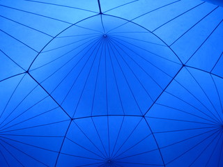 A blue geometric design on the ceiling of a large cloth tent