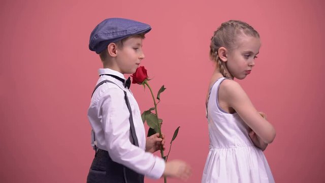 Gentleman boy with red rose apologizing to offended girlfriend, first love