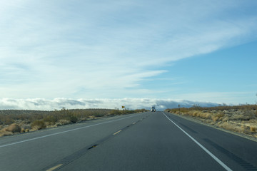 Semi emerges from the fog on a two lane freeway