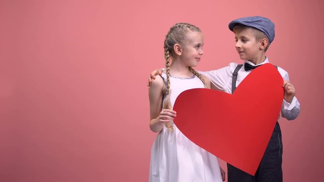 Young couple with big red heart hugging and smiling, romantic Valentines day
