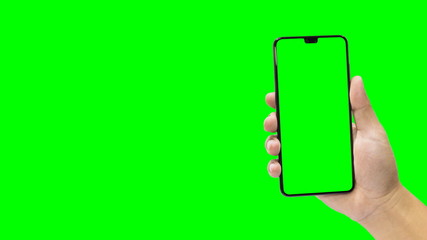 Man holding a black mobile phone with green screen isolated on a green background.