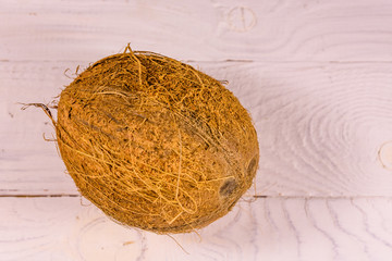 One whole coconut on a wooden table. Top view