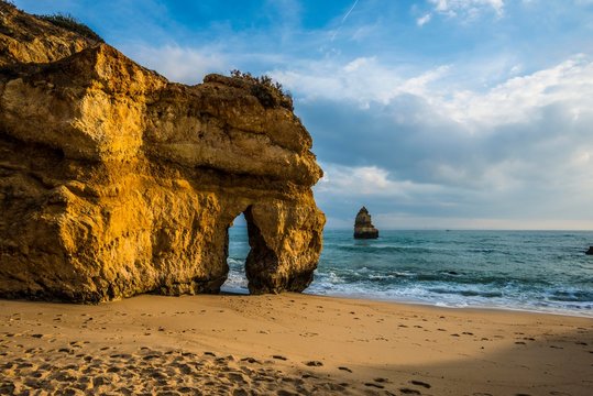 Rocky coast with beach and red rocks, Praia do Camilo, Lagos, Algarve, Portugal, Europe
