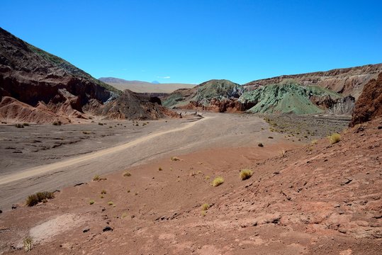 Desert landscape with dirt road in the Rainbow Valley, Valle Arcoiris, near San Pedro de Atacama, Region de Antofagasta, Chile, South America