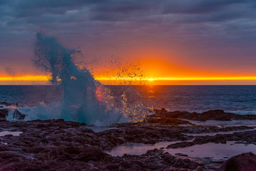 Big waves breaking onshore during sunset over ocean
