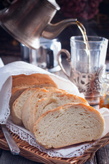 Homemade white bread with a cup of tea in the background, selective focus