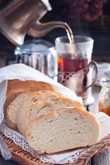 Homemade white bread with a cup of tea in the background, selective focus