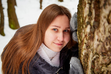 Portrait of a girl in a pine forest on a winter day