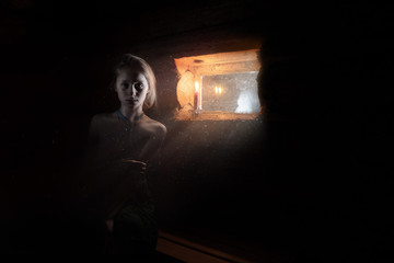 girl by the window in a wooden house with dim light