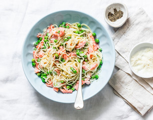 Smoked salmon, green peas, creamy sauce spaghetti  - delicious lunch in the mediterranean style. On a light background, top view