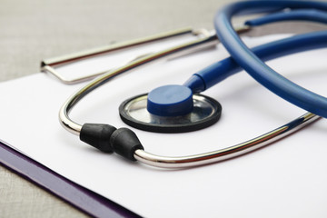 A stethoscope and a clipboard for notes as a medical check concept