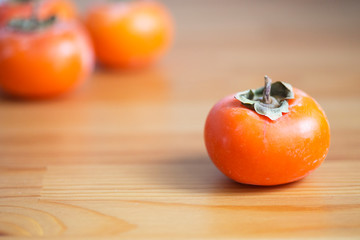 Ripe persimmon lying on a wooden table