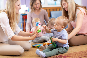 Group of young women communicate having a fun pastime with their children in playroom