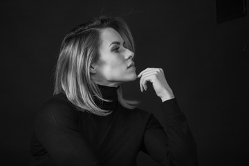 Dramatic black and white portrait of a beautiful woman on a dark background