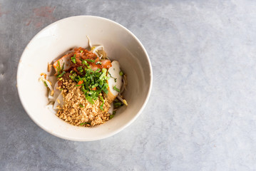 Top view of a bowl of spicy Thai Tom Yum noodle soup with pork.Bangkok,thailand.