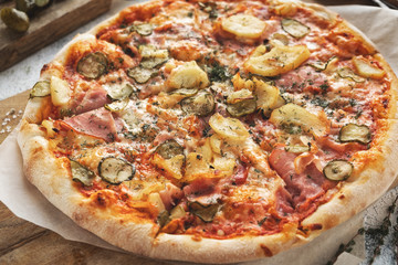 pizza with bacon and vegetables on a wooden board, closeup