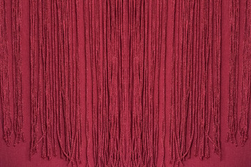 Maroon fabric with fringe. Close-up. Background