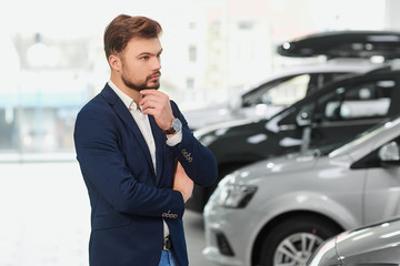 The buyer of the car thinks in the car dealership. 