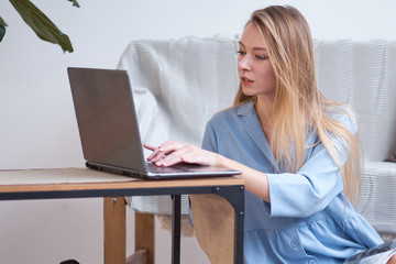 young beautiful woman at home drinking coffee and using a laptop for work. freelance for students