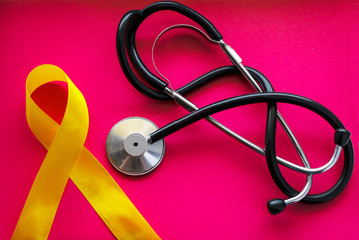 golden ribbon and medicine. concept - a symbol of childhood cancer, pediatric oncology