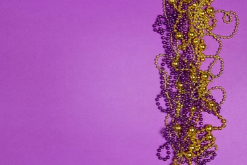 Mardi Gras beads on purple background.