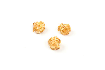 Few pieces caramel popcorn on white background.