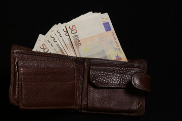 Wallet with money on a black background