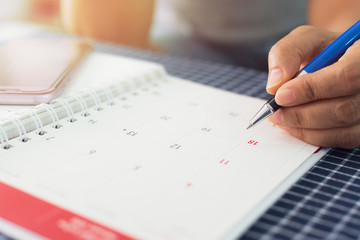 Hands of businesswoman is planning and managing work on the calendar.