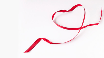 Heart of satin red ribbon-card for Valentine's day on white background. Top view.