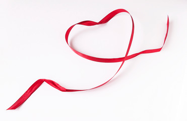 Heart of satin red ribbon-card for Valentine's day on white background. Top view.