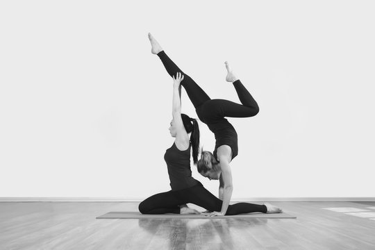Two slim girls are doing yoga