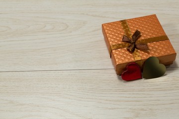Gift box and heart shape decoration on a wooden table