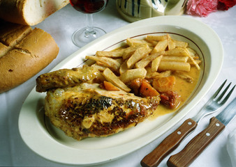 Plato con un cuarto de pollo y patatas fritas.